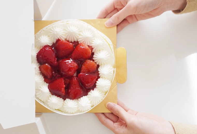 ケーキを箱から出しているイメージ